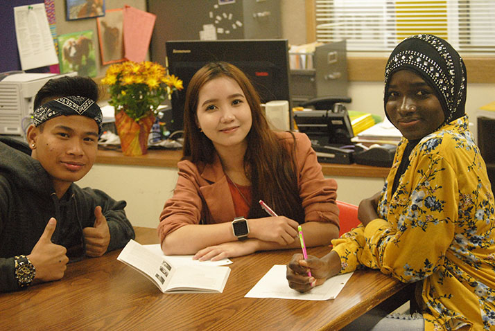 Left to right: Sophomores  Vuthi Vong, Gyshie Pinkihan, and Mariama Konteh are working on reading and analysing English language in Mrs. Van der Put’s ELL class.