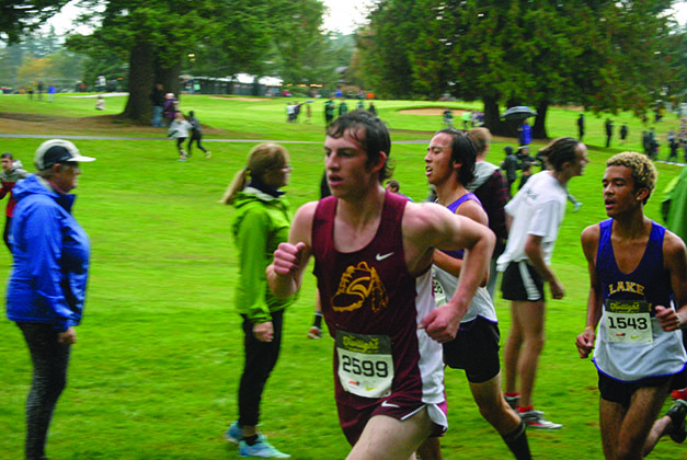 “The only good use for a golf course”: Senior Bryce Mefford and sophomore Ki Thomas approach the second mile marker in their Varsity Cross Country meet at Cedarcrest Golf Course. With only a mile left to go, Mefford injured his ankle and fell to his coaches seconds after this photo was taken. With a grimace, Mefford dropped out of the Varsity race and with his coaches help, limped back to the Lake Stevens XC tent. Though he was injured, Mefford is expected to make a fast recovery and race in at the Wesco Divisional Meet on October 21.
