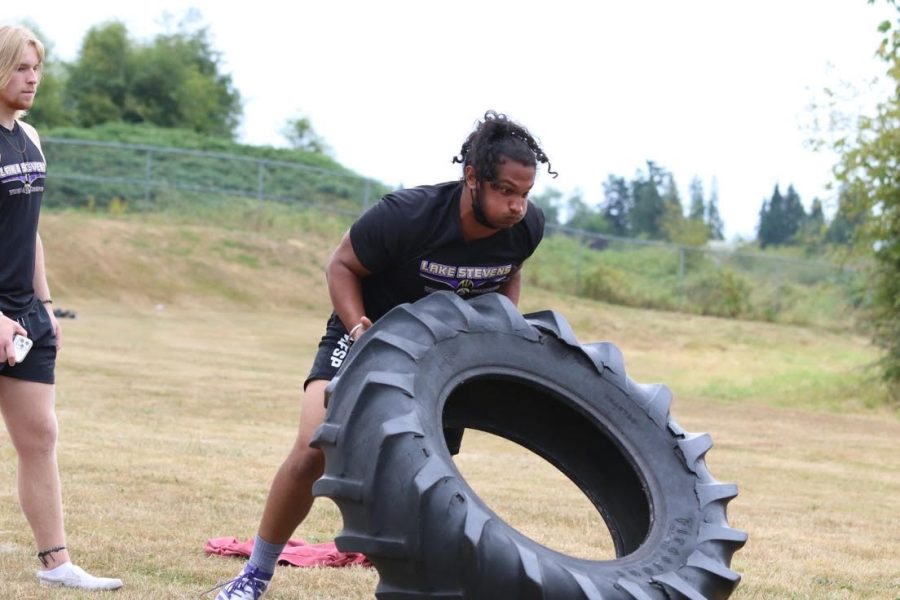 Hard Competition: Sophomore Naveer Kaile lifts a heavy tire and competes against other schools in the off-season. Naveer practiced for the upcoming season to be at peak performance. Being in the weight room, eating right, training right and training skills in the offseason and just not being lazy is what really defines your season, Kaile said.