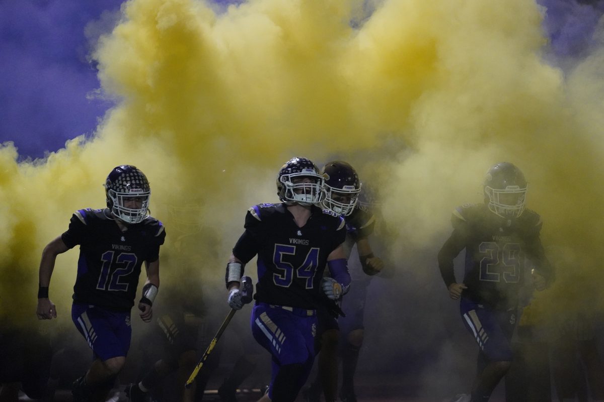 Junior Colton Matson and senior Mason Turner run out to the field before the Homecoming game on Oct. 20.