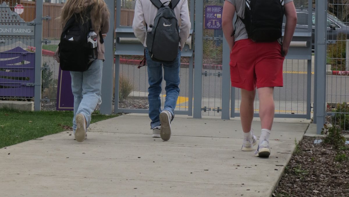 Three students disregard school policy as they walk out the east gates during fourth period.