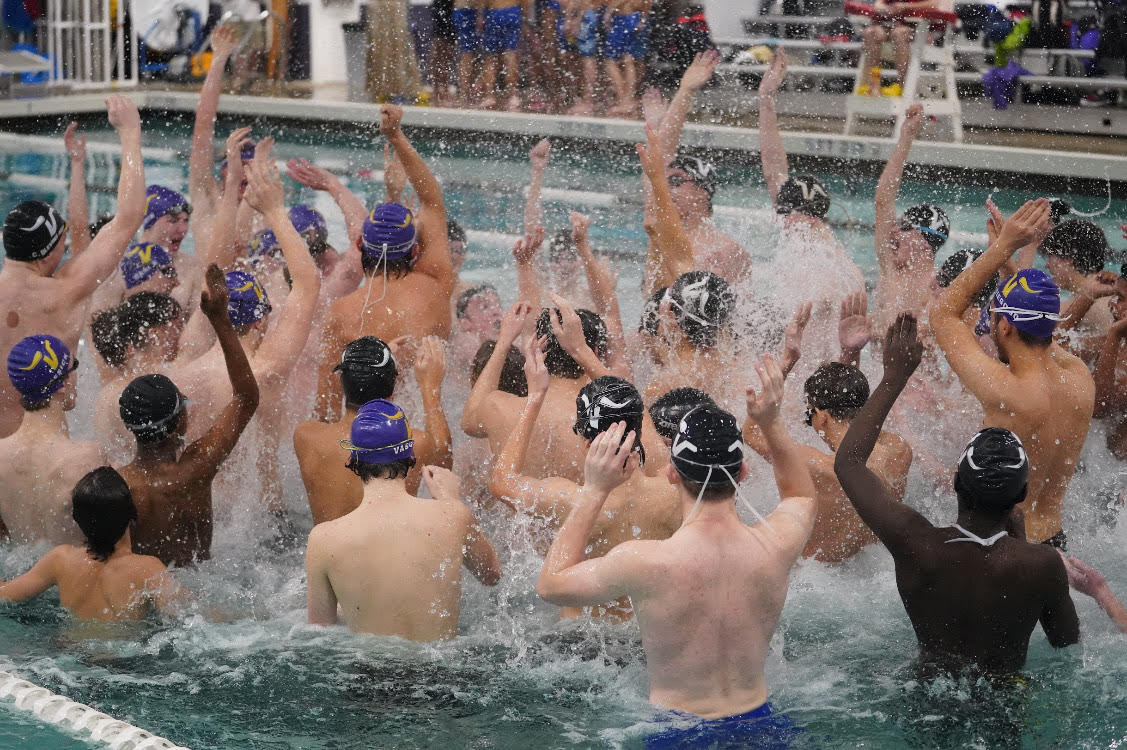 The boys swim team hype themselves up before a meet.