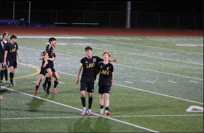 Juniors Shad Schmitt and Ian Ju celebrate as senior Grayson Wheeler and Caiden Ross hug after a dominant 10-1 win over Ferndale.