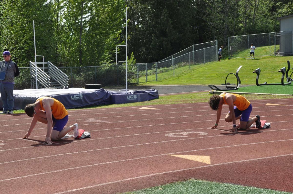 On your marks: Seniors David Brown (left) and Steven Lee Jr. (right) line up for the 300m hurdles race. David Brown came out on top, and Steven Lee Jr. earned third place.