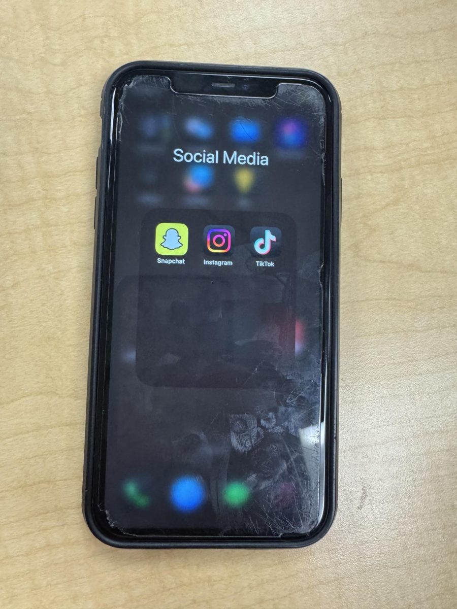 Phone laid down on a table with the apps Instagram, Snapchat, and Tiktok opened on the front screen