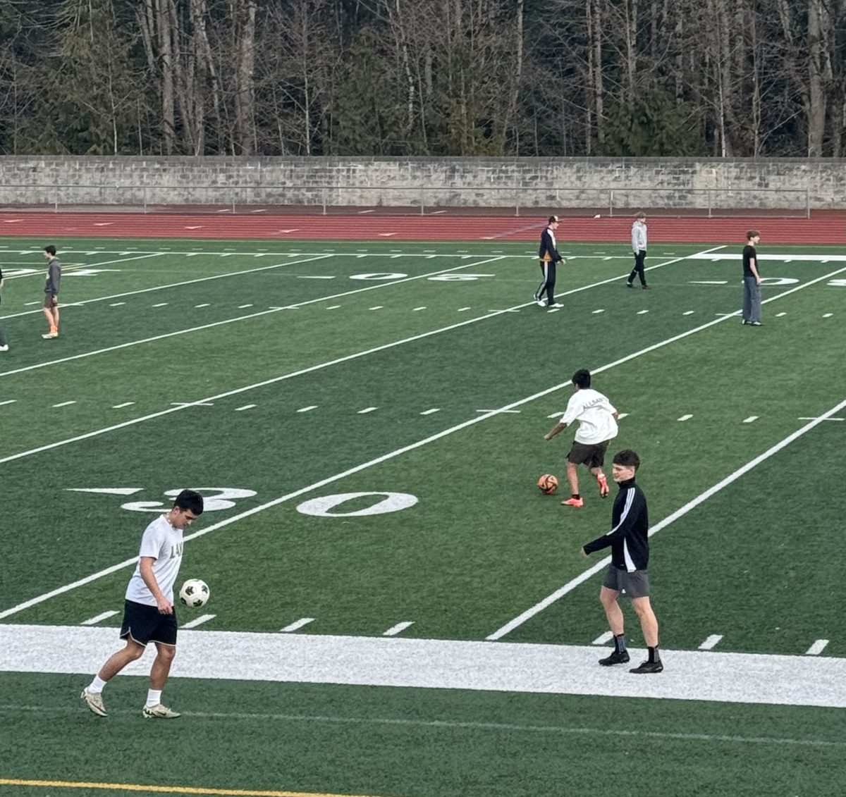 Seniors Brayden Zakimi and Shad Schmitt warm up their touches by passing the ball during open field.