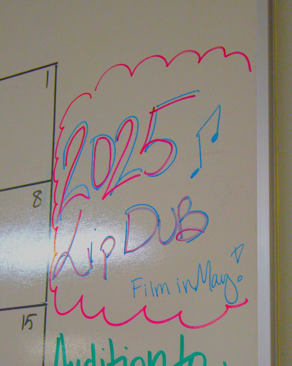The white board calendar advertises the 2025 lip dub. 