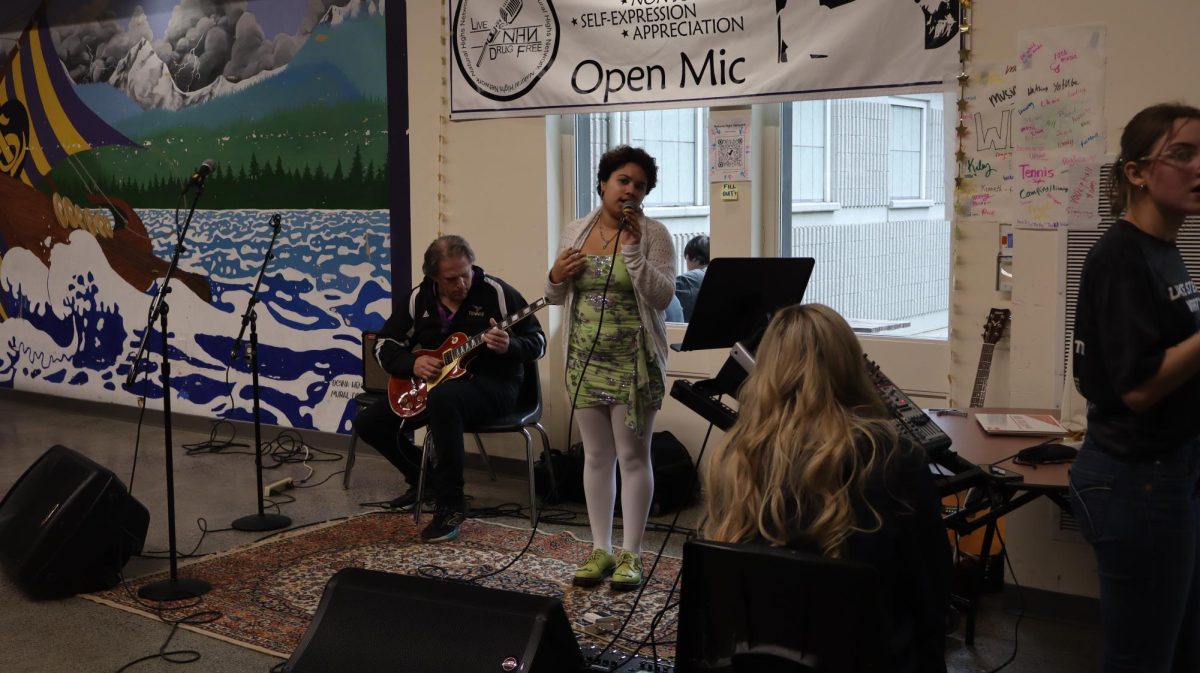Senior Serena Caine performs “Pale Pale Moon” by Jayme Lawson at the open mic.
