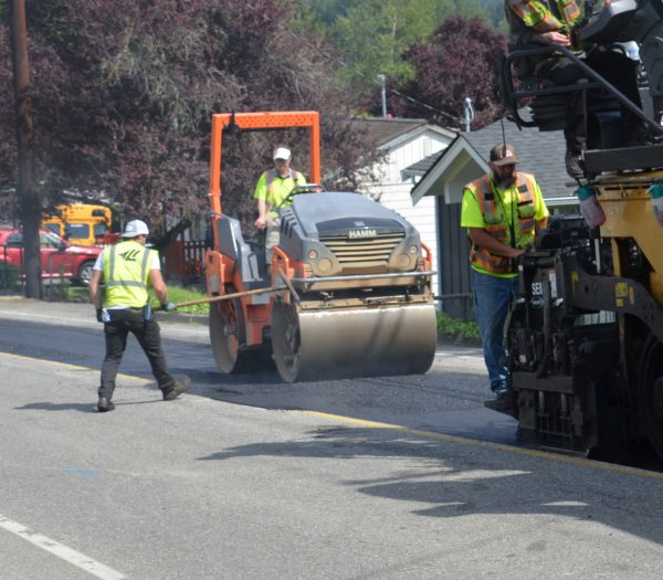Heavy machinery is used to flatten new concrete and  make the road smooth 